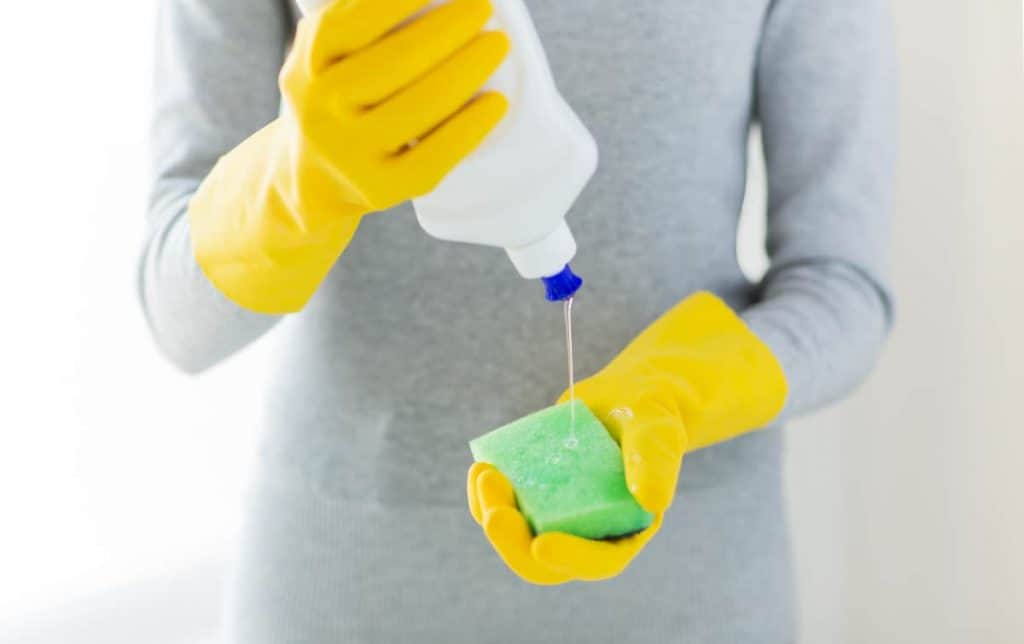 What is mild soap, close up of woman with sponge and cleanser